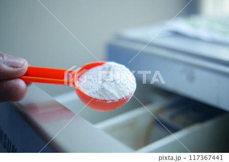 pouring Washing powder in plastic tray of washing machine  117367441