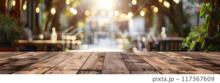 Front wooden plank table against a bright blurred cafe background with glowing street lanterns in the evening 117367609