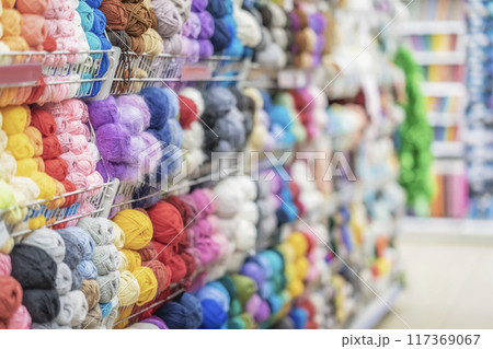 Blurred abstract background of store with assortment of knitting yarn. Skeins of yarn in store. Hobbies, needlework Blurred abstract background of store with assortment of knitting yarn. Skeins of yarn in store. Hobbies, needlework 117369067