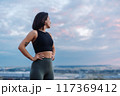 Confident Woman in Workout Gear Looking at Scenic Sky During Outdoor Fitness Session 117369412
