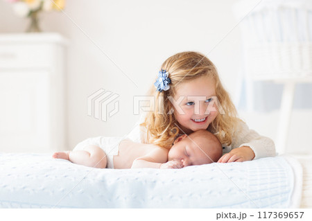 Little girl playing with newborn baby brother 117369657
