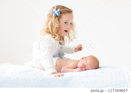 Child watching newborn baby in bassinet. 117369667