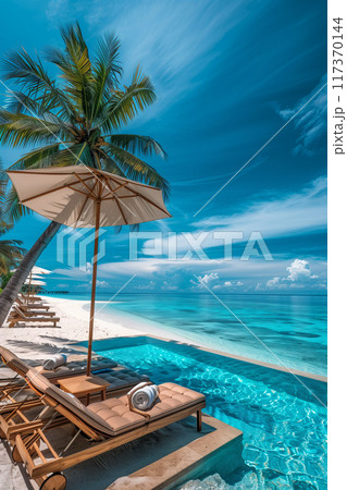 A gorgeous tropical beach resort with a swimming pool and sun loungers on a white sandy beach. Blue sky and palm trees Beautiful scenery of a luxurious summer vacation. 117370144