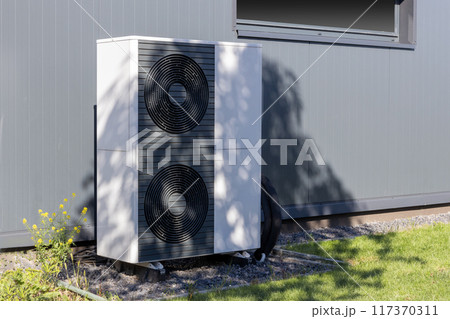 Heat pump unit installed outside a modern building Heat pump unit installed outside a modern building 117370311