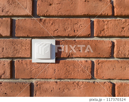 White Electrical Outlet on Red Brick Wall 117370324