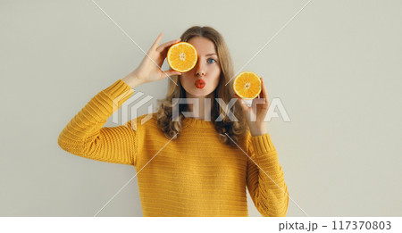 Nutrition, diet vegetarian concept. Happy healthy cheerful young woman with slices of orange fruits 117370803