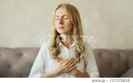 Young woman grabbing put hands on her chest suffering from heart pain, feeling bad with acute pain Young woman grabbing put hands on her chest suffering from heart pain, feeling bad with acute pain 117370818