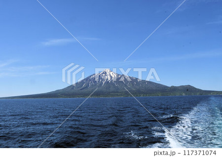 利尻島から離れてゆくフェリーから写した青空を背景に前方に波しぶきの筋を引いた美しい残雪の利尻富士 利尻島から離れてゆくフェリーから写した青空を背景に前方に波しぶきの筋を引いた美しい残雪の利尻富士 117371074