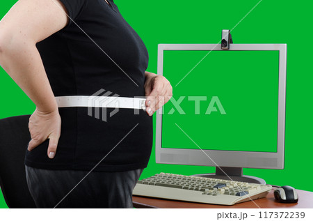 Overweight Woman Measures Waist Circumference in Front of Chroma Key Monitor, Sharing Data with Telemedicine Doctor for Remote Obesity Management and Weight Loss Tracking. 117372239