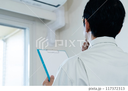 エアコンの点検をする男性 117372313