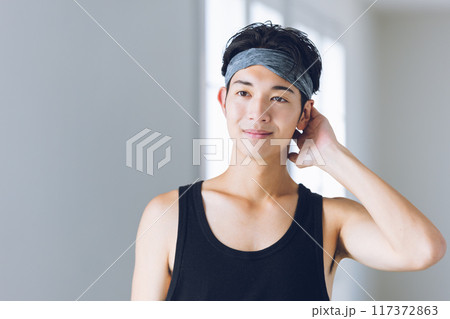 ヘアバンドを着けて鏡を見つめる若い男性 117372863