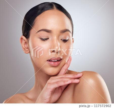 Her beauty catches everyones attention. Studio shot of a beautiful young woman posing against a grey background. 117372902