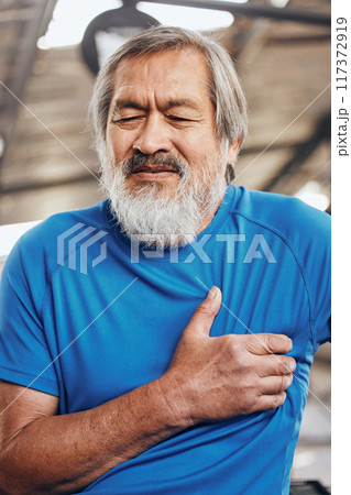 Sports, gym and old man with pain in chest, medical emergency during workout at fitness studio. Exercise, health and wellness, stressed asian senior person with hand on heart while training in Japan. 117372919