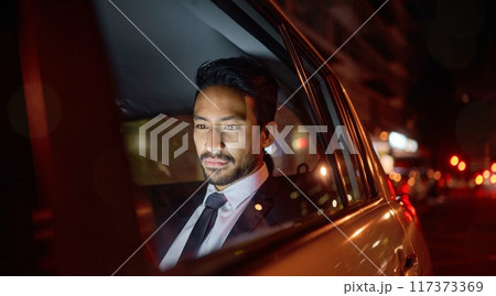 Night, travel and business man in car relaxing, commuting and traveling after working. Transport, road and young male professional, passenger or businessman sitting in vehicle, motor or taxi in city. 117373369