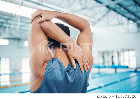 Rear view, man and stretching at swimming pool for training, cardio and exercise, indoor and flexible. Hand, back and swimmer stretch before workout, swim and fitness routine, warm up and preparation Rear view, man and stretching at swimming pool for training, cardio and exercise, indoor and flexible. Hand, back and swimmer stretch before workout, swim and fitness routine, warm up and preparation 117373520