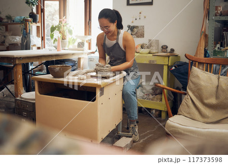 Clay, creative or woman in pottery workshop working on a cup sculpture or mug mold in small business. Focus, artistic girl or happy Japanese designer manufacturing handicraft products as entrepreneur Clay, creative or woman in pottery workshop working on a cup sculpture or mug mold in small business. Focus, artistic girl or happy Japanese designer manufacturing handicraft products as entrepreneur 117373598
