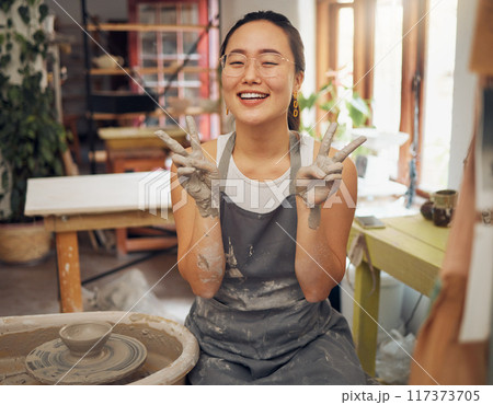 Pottery, peace and clay hands portrait of woman in workshop for small business art class. Asian person with happy emoji for wheel production or spinning as creative motivation, support and success. Pottery, peace and clay hands portrait of woman in workshop for small business art class. Asian person with happy emoji for wheel production or spinning as creative motivation, support and success. 117373705