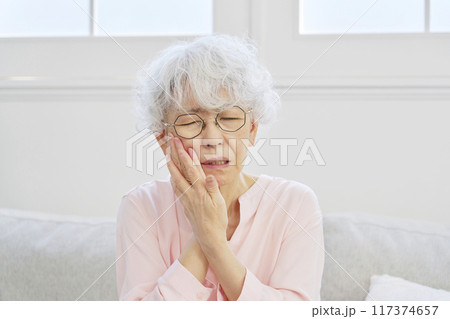 歯が痛いシニア女性　リビングルーム 117374657