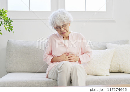 腹痛のシニア女性　リビングルーム 117374666