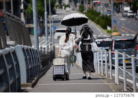 真夏の都市の街で歩く二人の若い女性の後ろ姿 真夏の都市の街で歩く二人の若い女性の後ろ姿 117375676