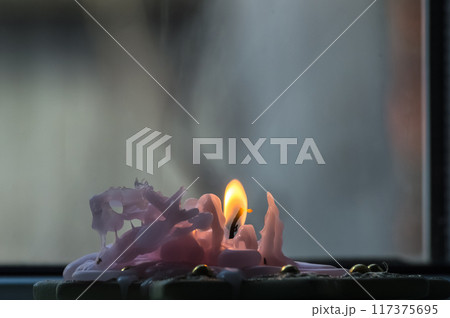 Burning candle on a window sill, close-up, selective focus Burning candle on a window sill, close-up, selective focus 117375695