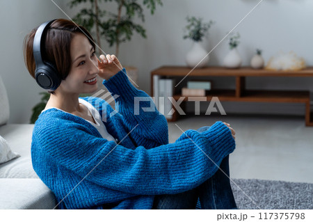 リビングで音楽を聴くミドルの女性 リビングで音楽を聴くミドルの女性 117375798