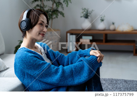 リビングで音楽を聴くミドルの女性 リビングで音楽を聴くミドルの女性 117375799