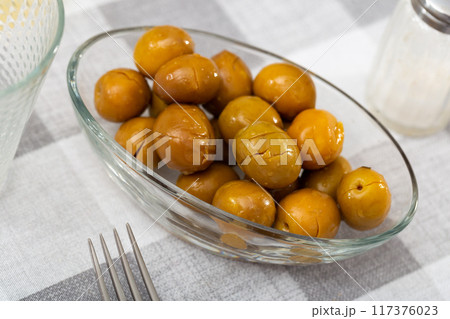 Closeup of plate of pickled green olives with stone, spanish appetizer Closeup of plate of pickled green olives with stone, spanish appetizer 117376023