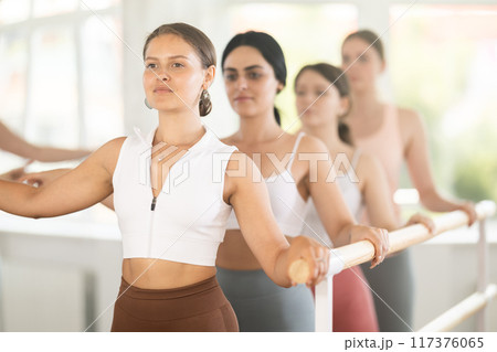 Ballet rehearsal in dance studio - young ballerinas stand in second position near ballet barre Ballet rehearsal in dance studio - young ballerinas stand in second position near ballet barre 117376065