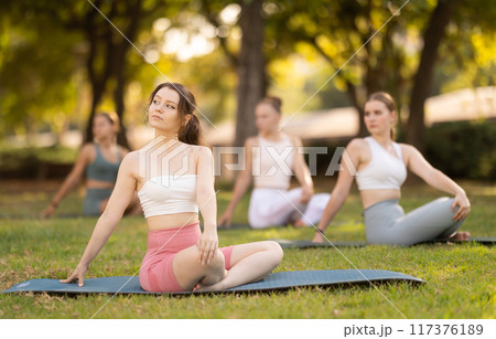 Yoga lesson visitors girls perform padmasana in park 117376189