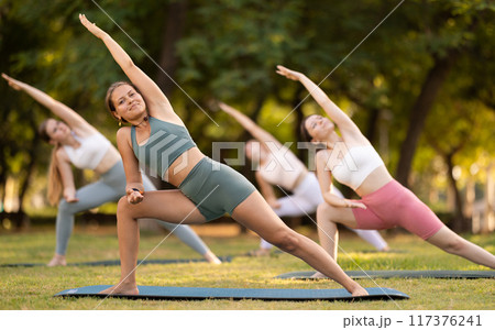 Group of young women doing stretching in park 117376241