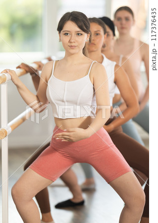 Young ballerinas practicing demi plie at barre in choreography studio 117376435