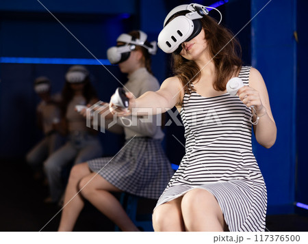 Excited young girl playing virtual reality game Excited young girl playing virtual reality game 117376500