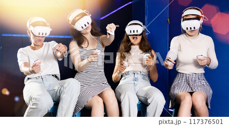 Girls wearing VR headsets and playing games. Modern bachelorette party Girls wearing VR headsets and playing games. Modern bachelorette party 117376501