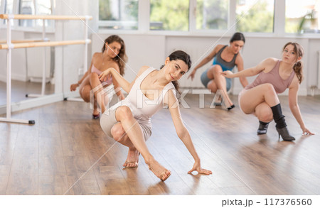 Dancing training in high heels for slender beautiful women in dance studio 117376560
