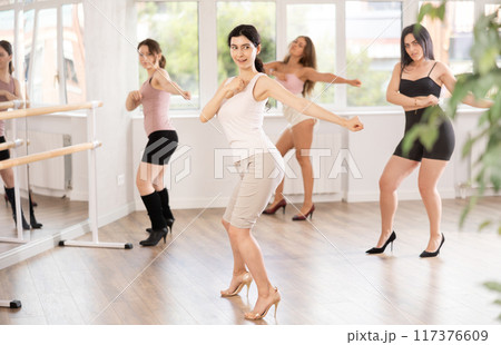 Group of girls learn to dance in high heels in dance studio 117376609