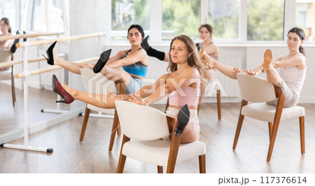 Young girl performing burlesque dance on chair at group class 117376614