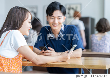 カフェでスマホを見る若い男性 カフェでスマホを見る若い男性 117376616