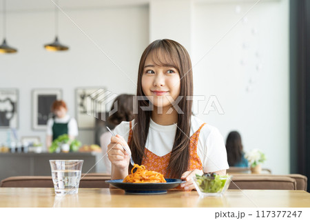 カフェでパスタを食べる若い女性 カフェでパスタを食べる若い女性 117377247
