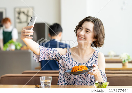 カフェで写真を撮るインバウンドの外国人女性　 117377444