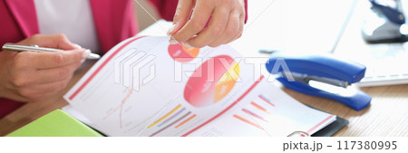 Businesswoman analysing financial and marketing documents in office 117380995