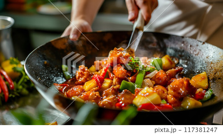 Asian Chef Preparing Sweet and Sour Chicken in a Wok 117381247