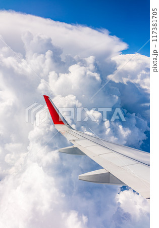View from the airplane window at a beautiful cloudy sky and the airplane wing 117381705
