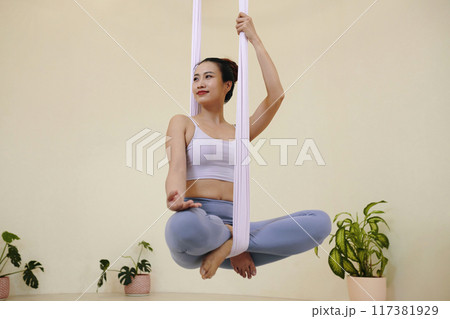 Practicing Aerial Yoga Poses with Calm Expression Practicing Aerial Yoga Poses with Calm Expression 117381929