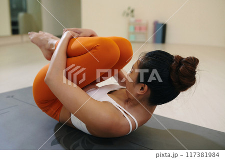 Practicing Yoga Pose on Exercise Mat in Indoor Setting Practicing Yoga Pose on Exercise Mat in Indoor Setting 117381984