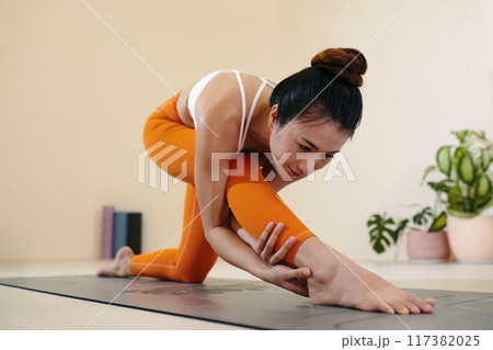 Practicing Yoga with Flexibility and Grace in Studio Setting Practicing Yoga with Flexibility and Grace in Studio Setting 117382025