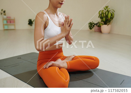 Practicing Meditation in Bright Modern Yoga Studio Practicing Meditation in Bright Modern Yoga Studio 117382055