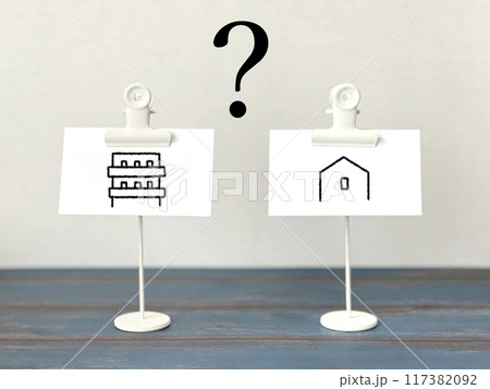 2つ白い紙にマンションと家のイラストとクエスチョンマーク_青板 117382092