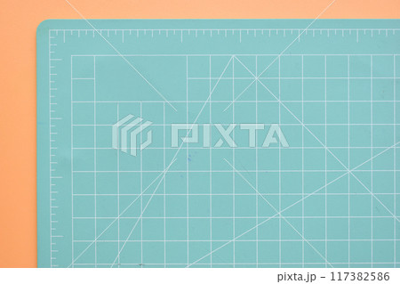 green cutting mat on orange background, object tool for design green cutting mat on orange background, object tool for design 117382586