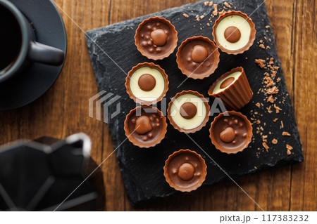Sweet pralines. Chocolate truffles on wooden table. Top view. 117383232